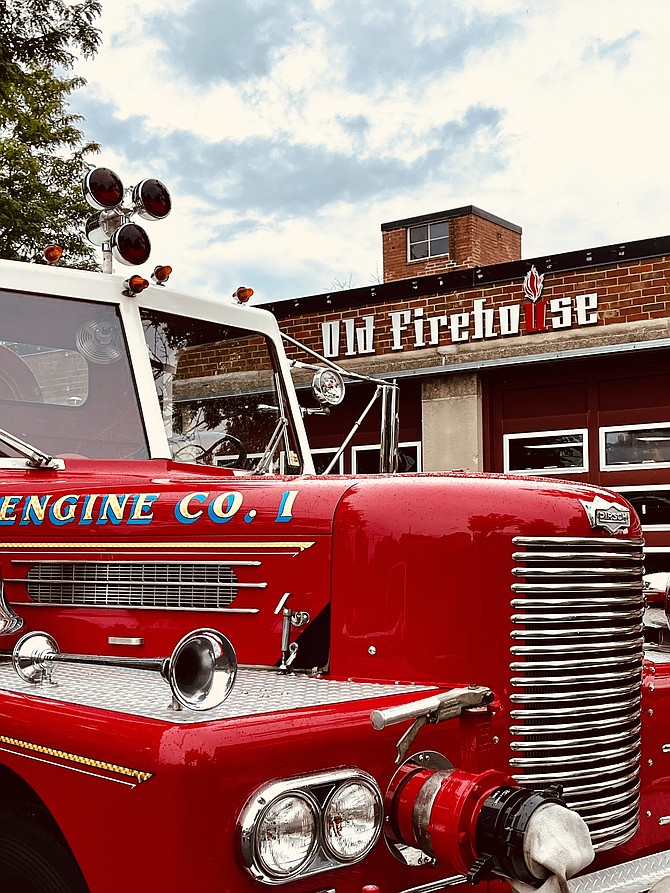 a vintage firetruck parked in front of the Old Firehouse Center