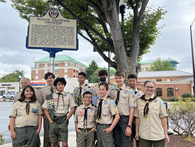 Scout troop standing in front of a historical marker at the Old Firehouse Center