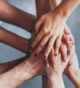 Various hands clasping