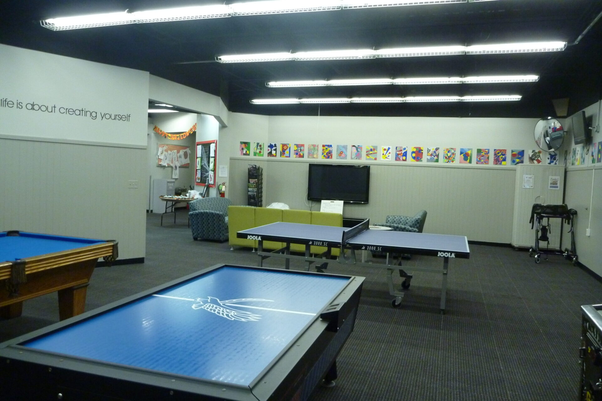 air hockey table, pool table and ping pong table in the game room at the Old Firehouse Center