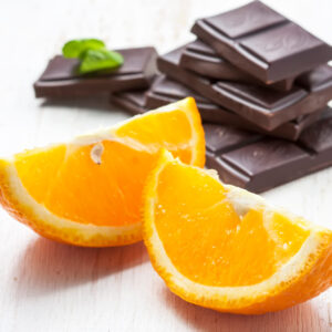 sliced oranges with dark chocolate on a white background wooden, selective focus