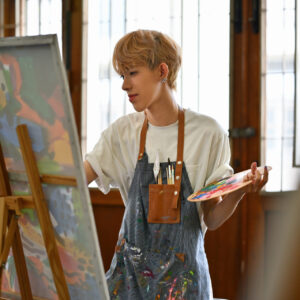 Young Asian LGBT artists doing artwork in the workshop studio.
