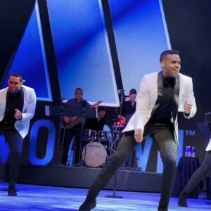 Uptown members dancing on stage.