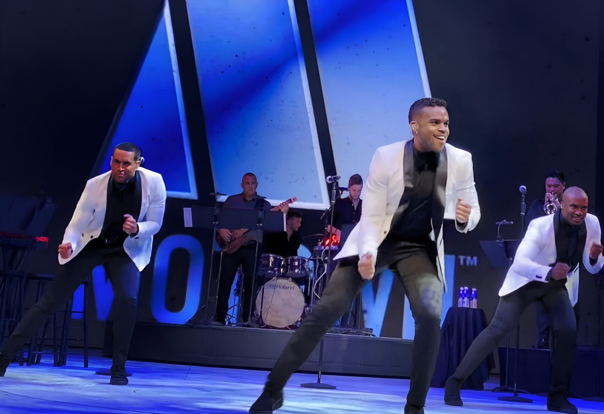 Uptown members dancing on stage.