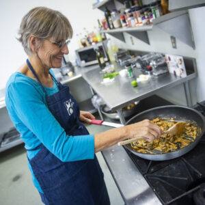 Senior cooking at the stove in the MCC kitchen