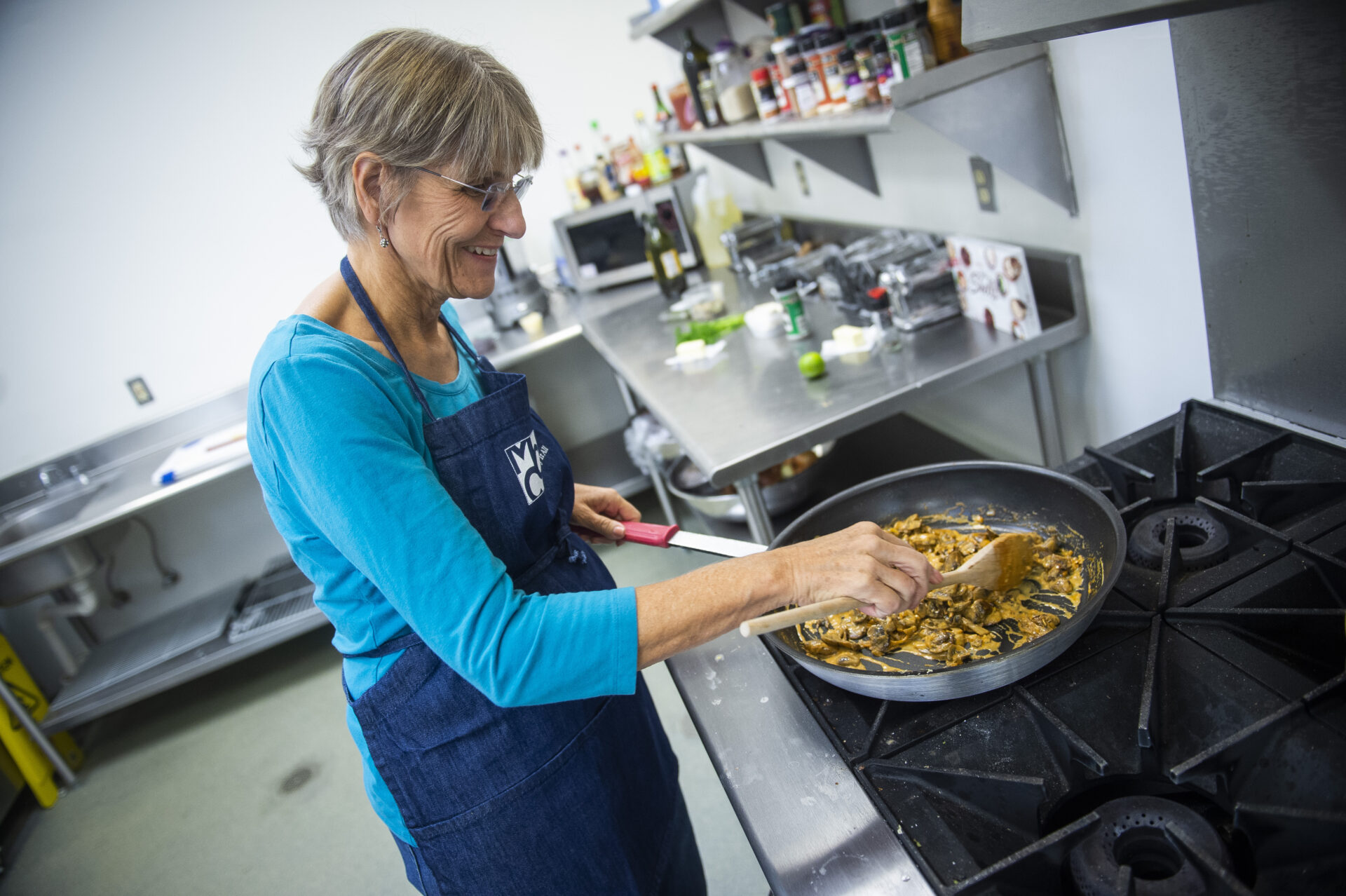 Senior cooking at the stove in the MCC kitchen