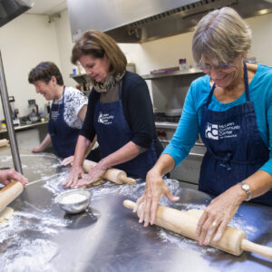 Seniors rolling dough in the MCC kitchen