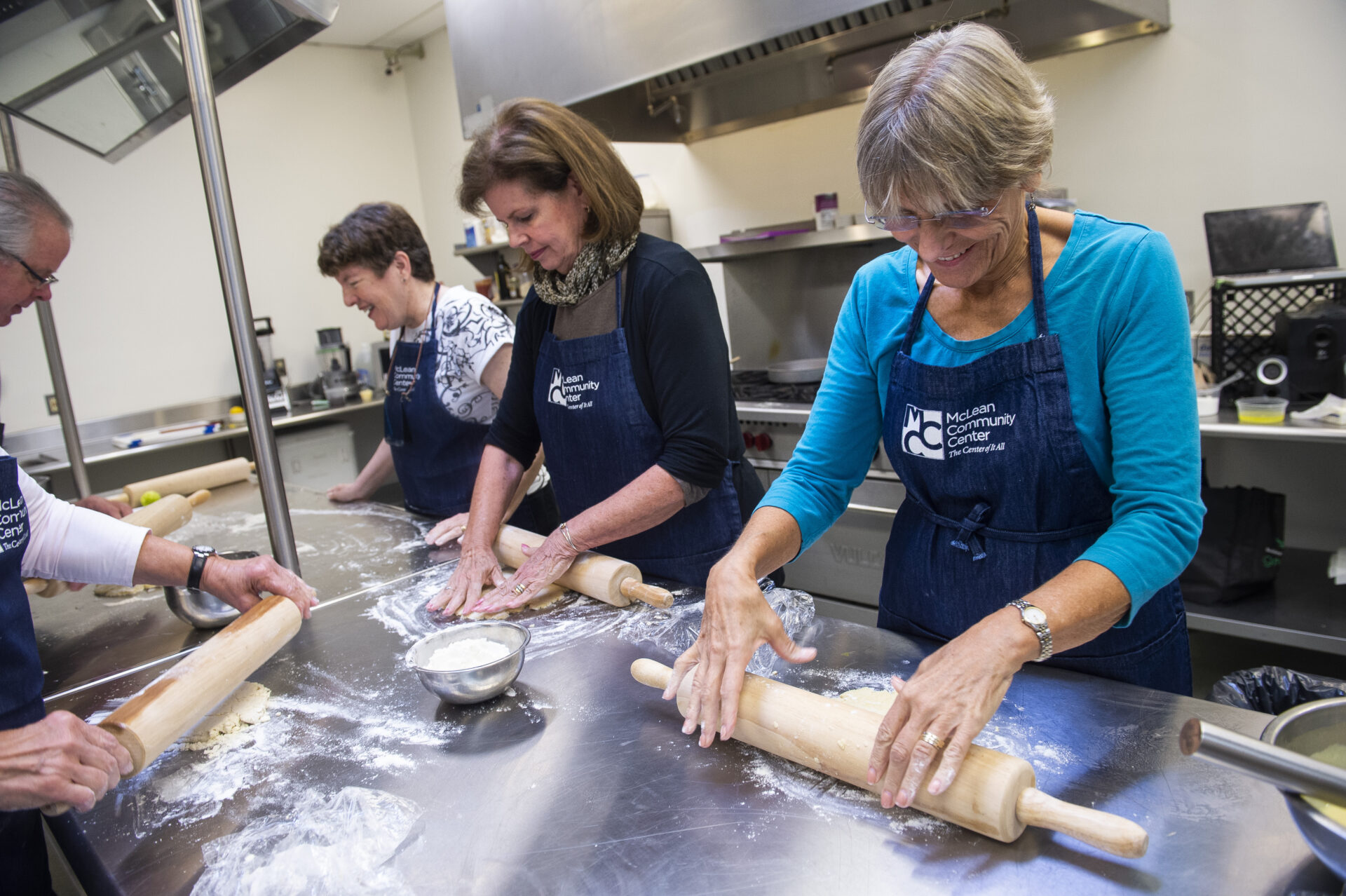 Seniors rolling dough in the MCC kitchen
