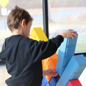 Young boy building with oversized blocks