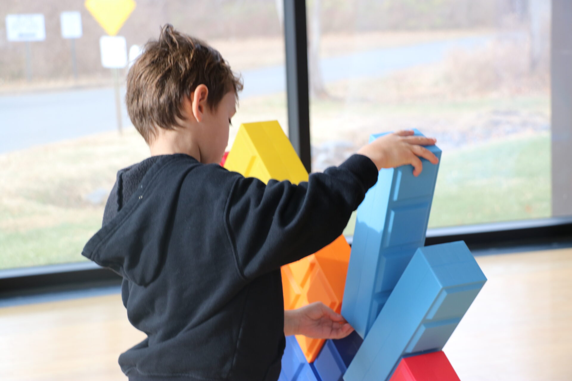 Young boy building with oversized blocks