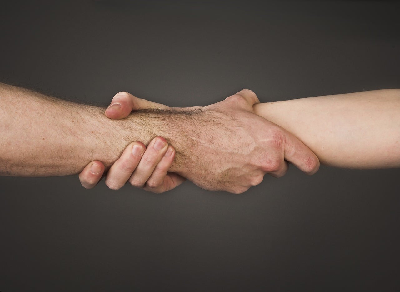 Two hands holding each other at the wrist