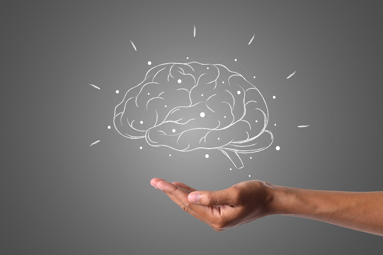 Hand holding an illustration of a brain